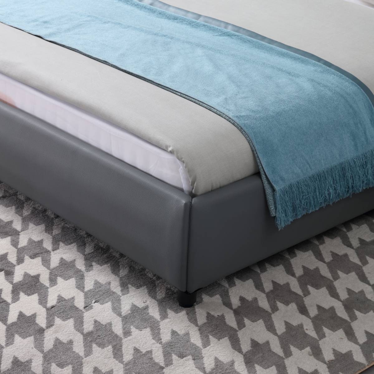 Close-up of the bed frame corner and blue throw blanket