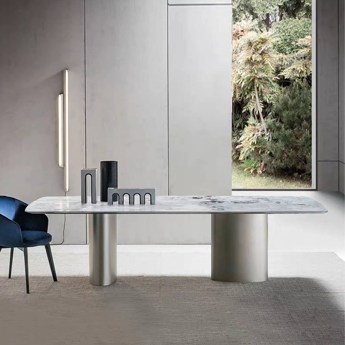 Side view of dining table with grey sintered stone top and cylindrical stainless steel legs