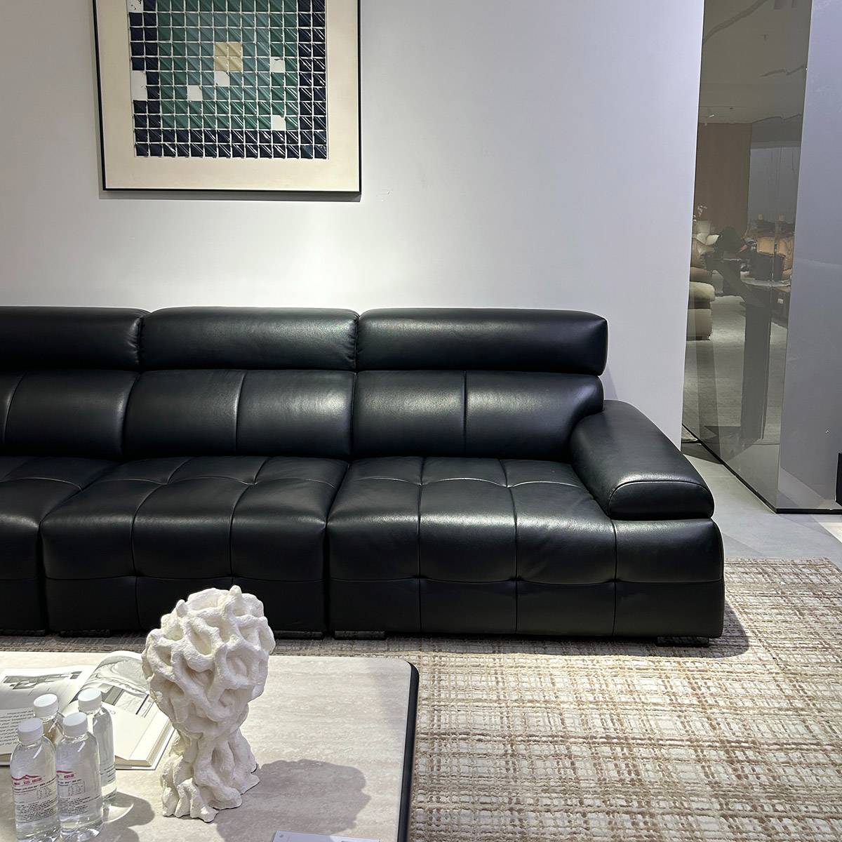 Side view of black leather sofa showing high back and armrest design