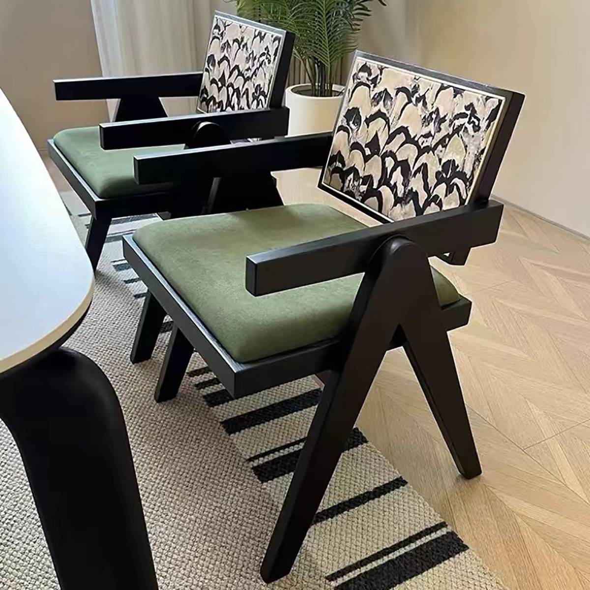 Mid-century modern dining chair with black frame, green seat, and abstract backrest