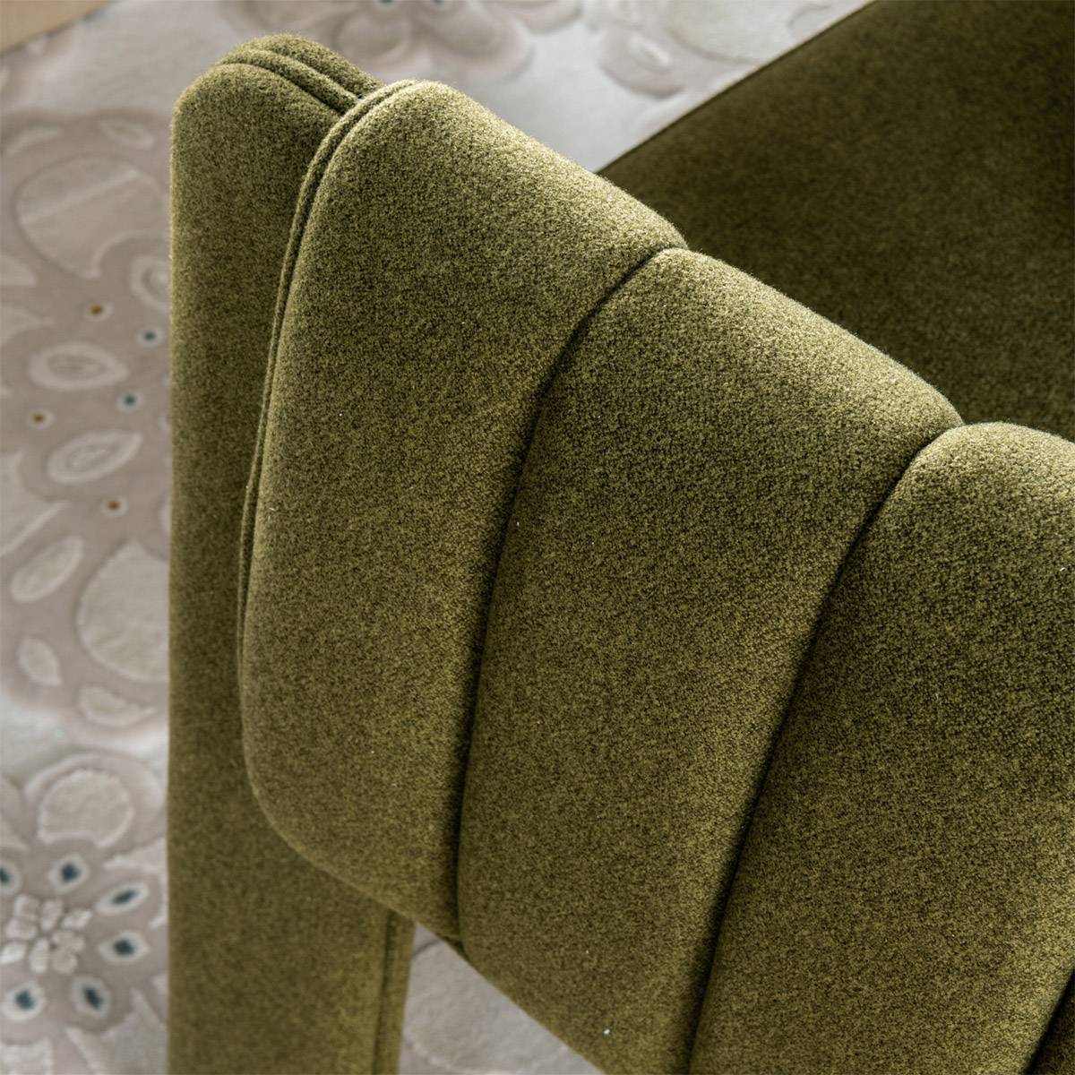 Close-up detail of the green fabric texture and armrest