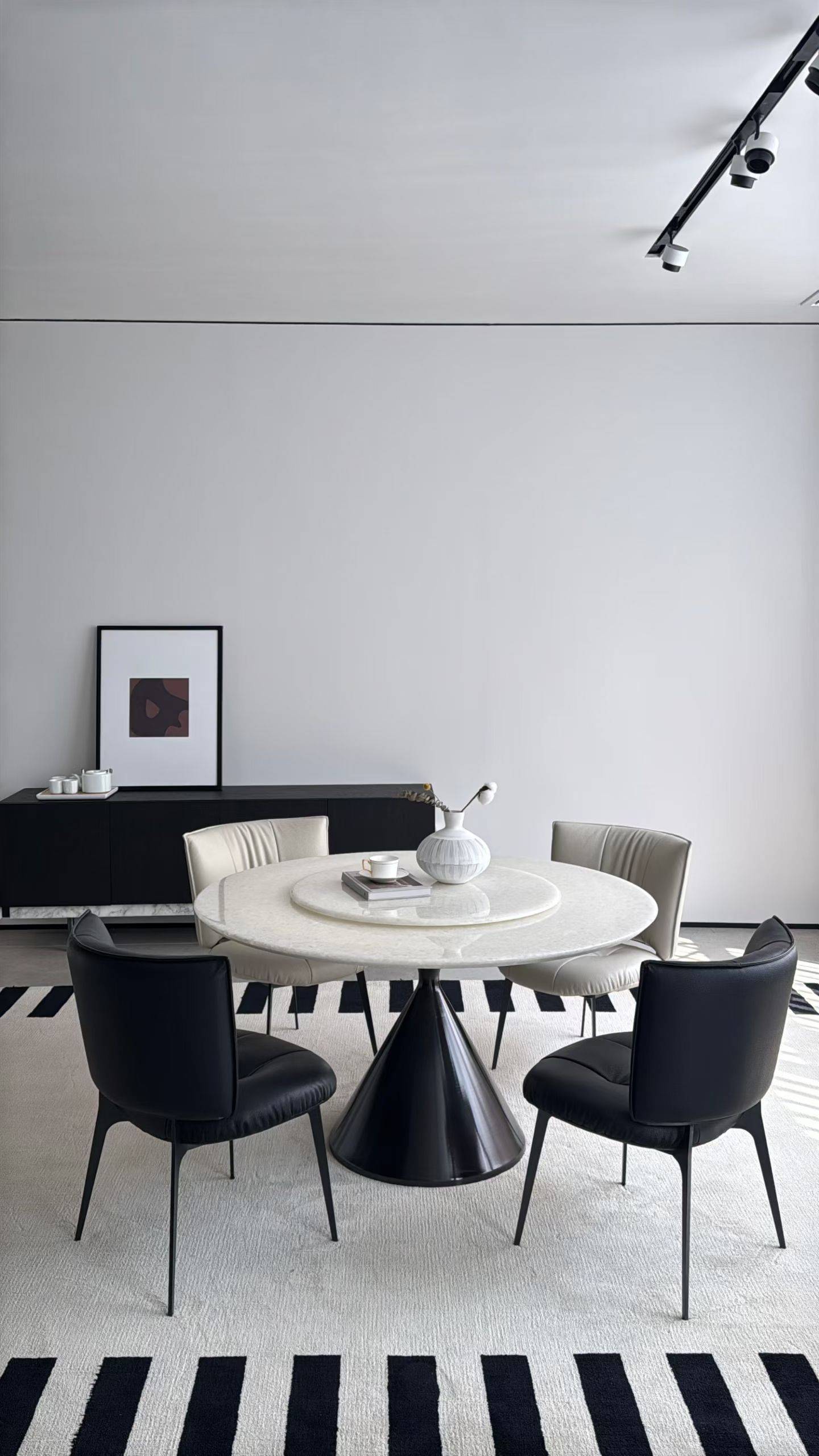 Black and beige dining chairs arranged around a round dining table in a modern minimalist room