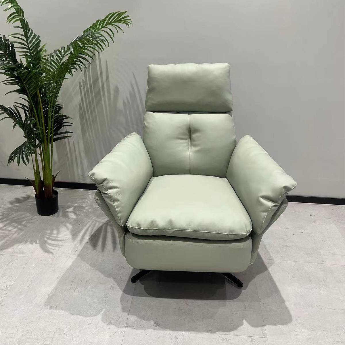 Front view of a light green modern recliner lounge chair with a swivel base