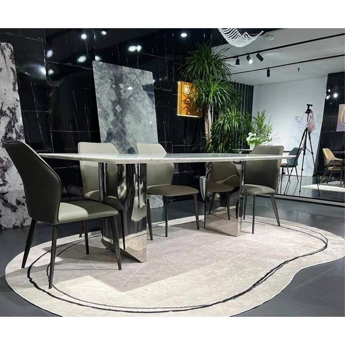 Side angle view of the marble dining table showing the mirror base and surrounding chairs