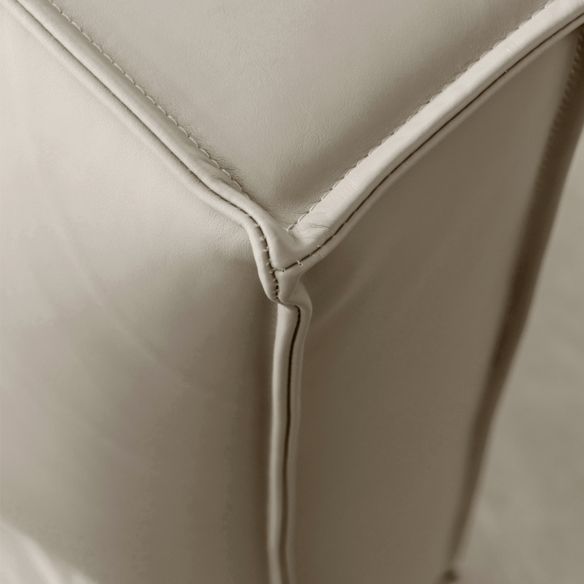 Close-up detail of the stitching and leather texture on the bed headboard