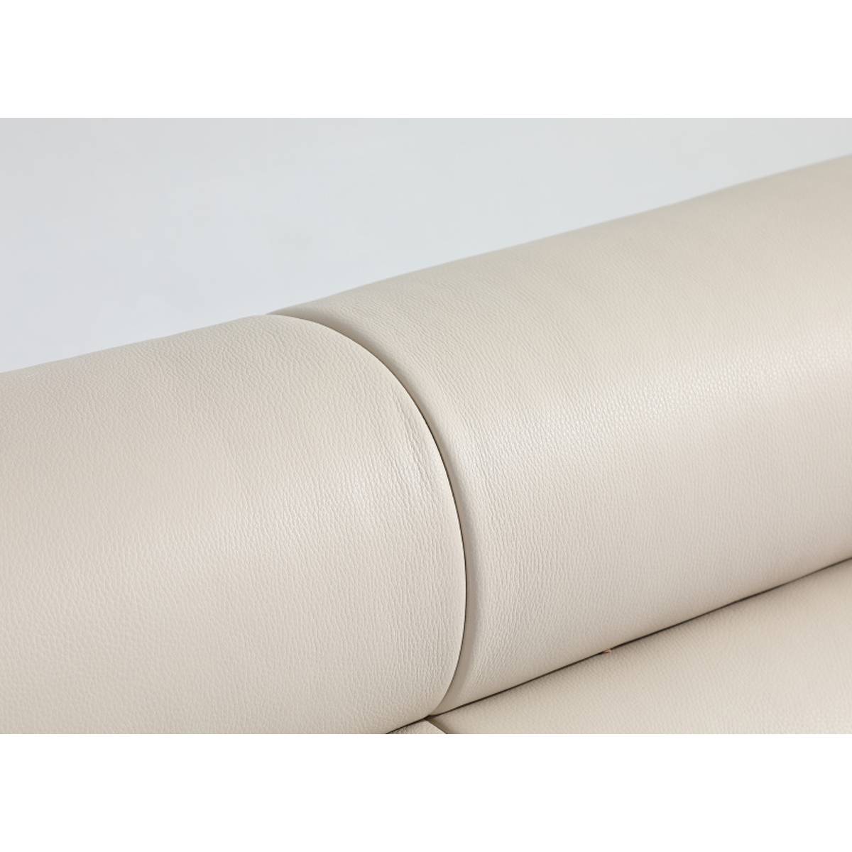 Close-up detail of the beige leather headboard showing the texture and stitching