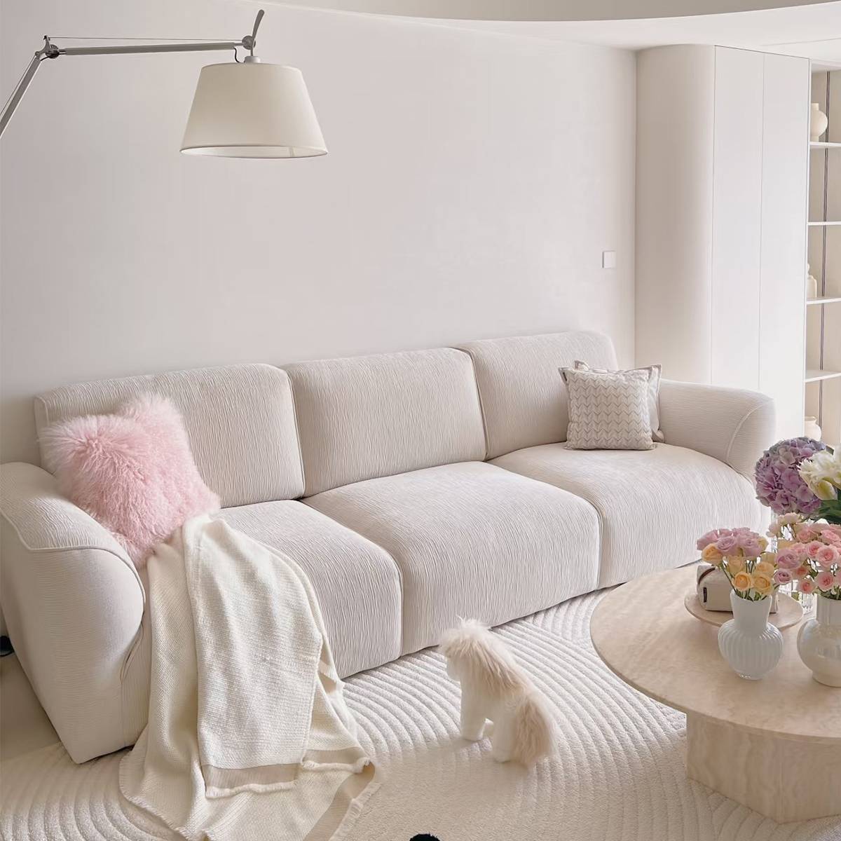 Lifestyle shot of the B12 Grande sofa in a living room setting with a pink pillow and throw blanket