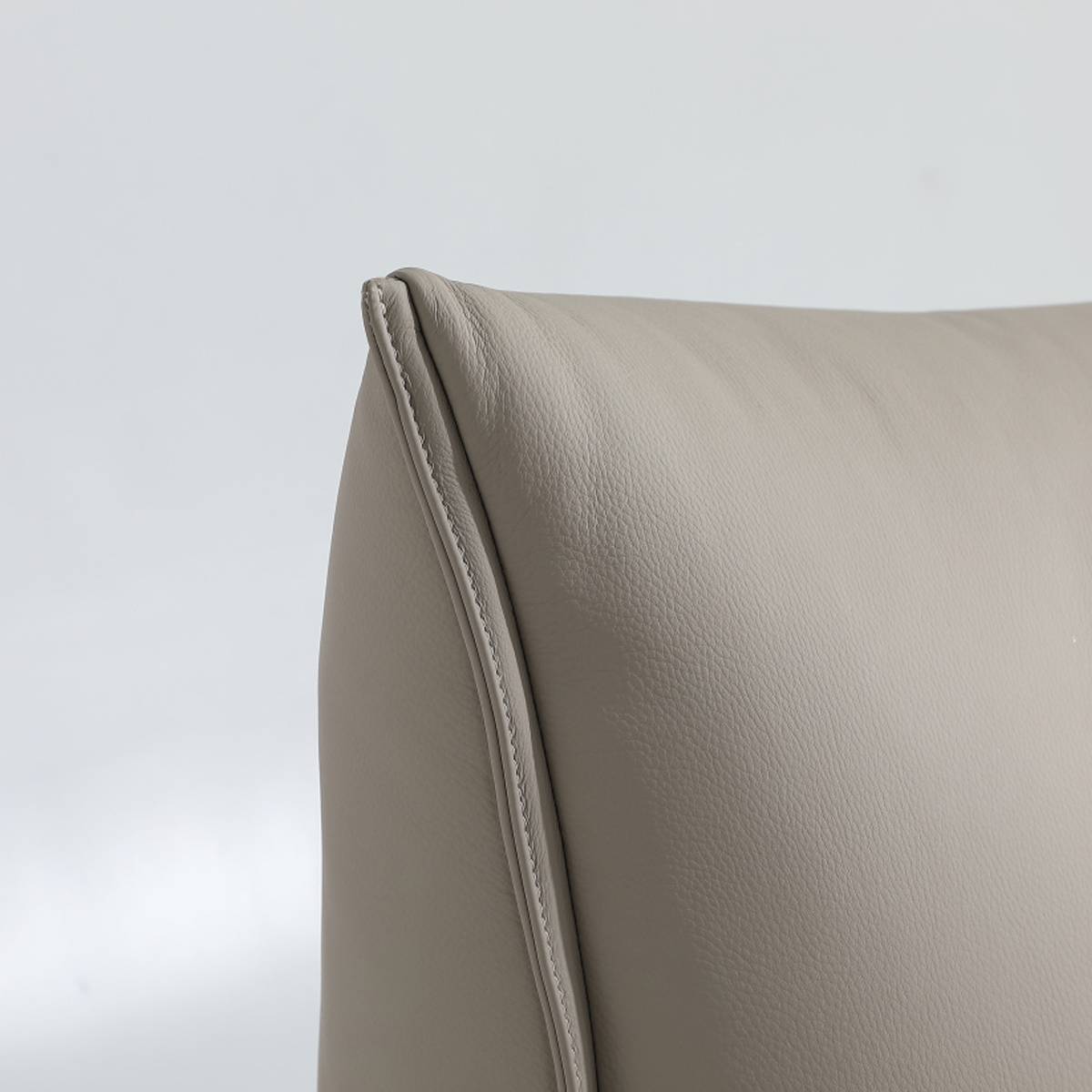 Close-up detail of the leather stitching and texture on the bed frame