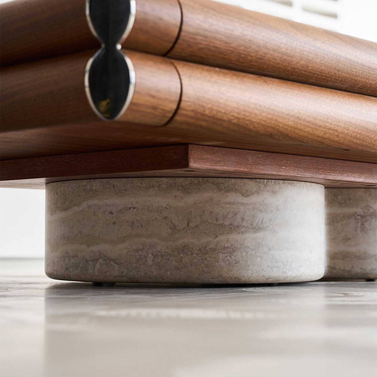 Close-up detail of the travertine base and stainless steel corner hardware