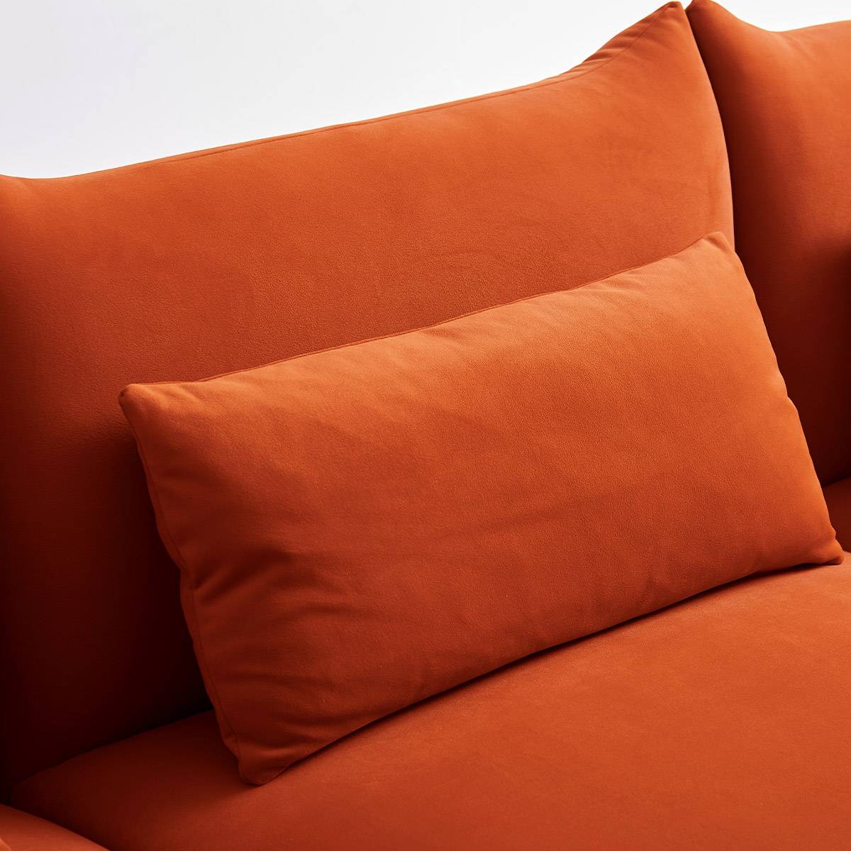 Close-up view of the orange fabric back cushion and throw pillow