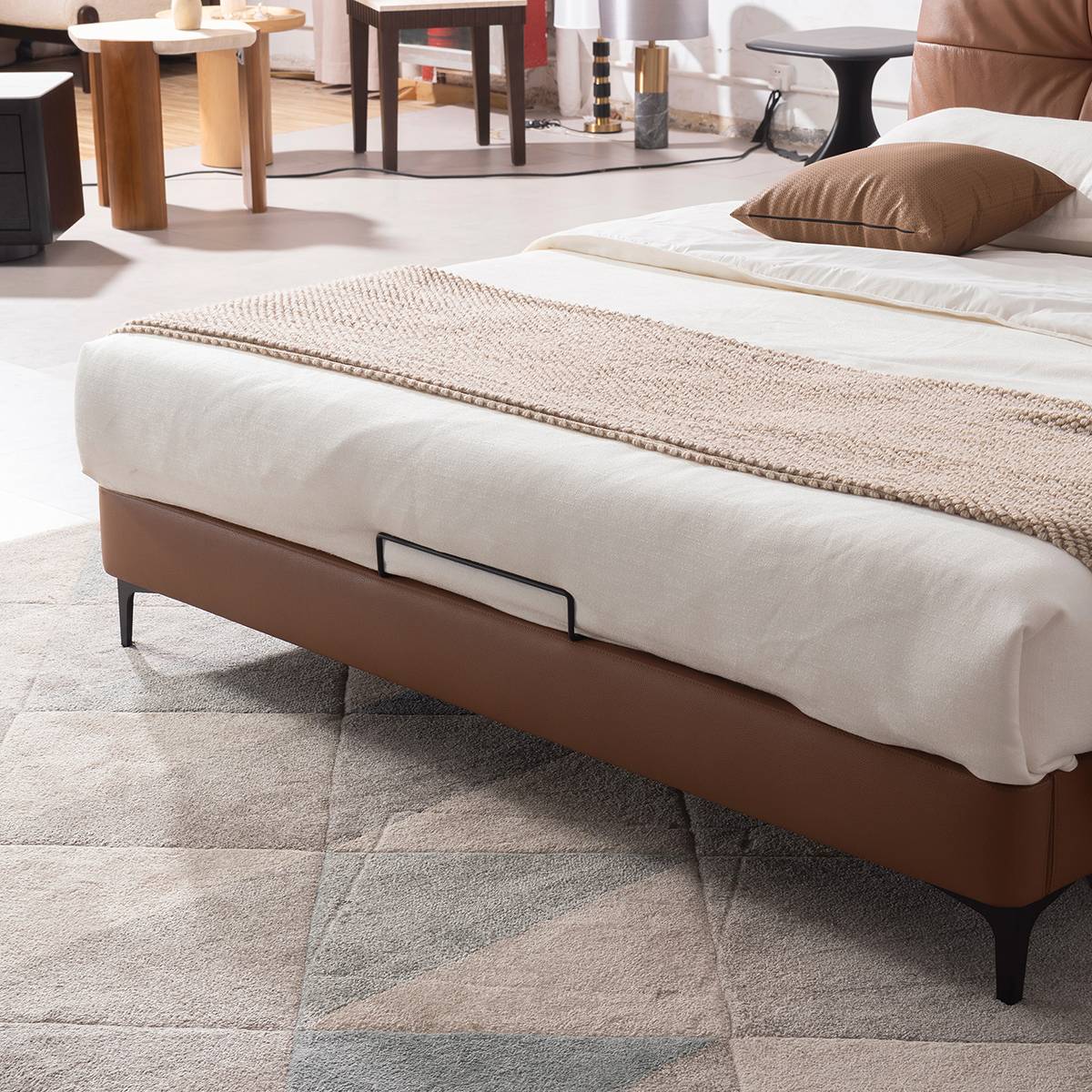 Close-up view of the brown leather bed frame and metal handle detail