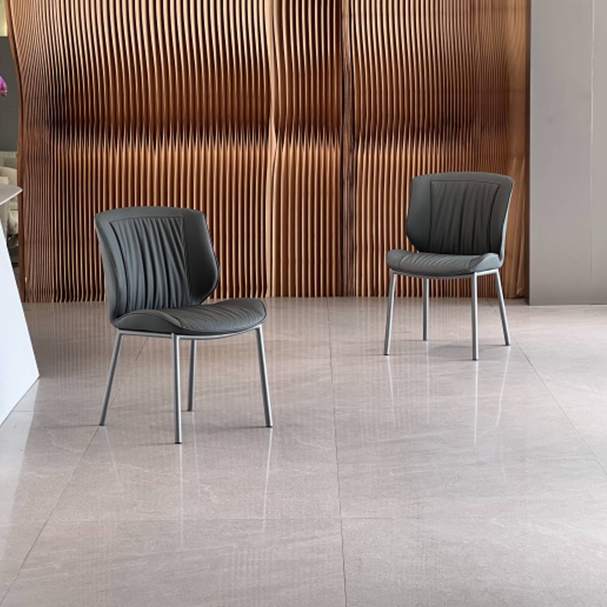 Two dark grey dining chairs placed in a modern interior setting