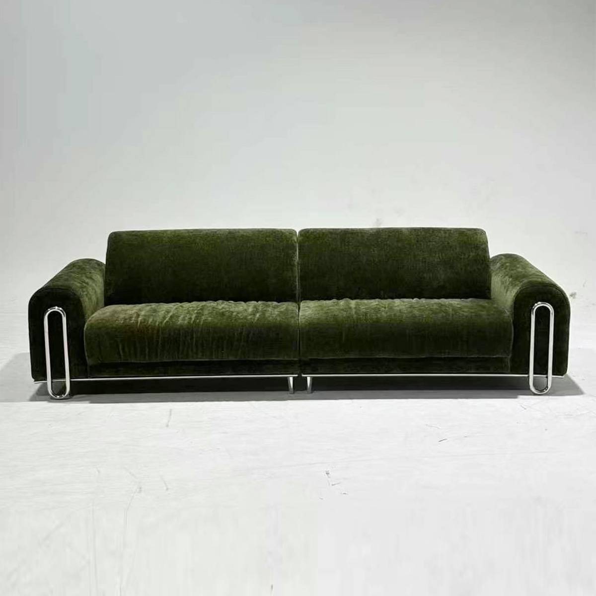Front view of the green sofa showing the two-seat configuration and chrome legs