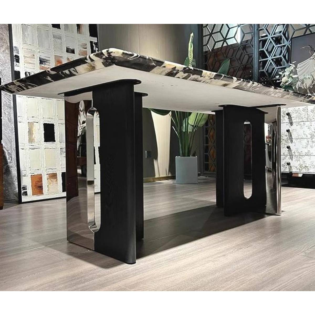 Full view of the dining table in a showroom setting, displaying the T-shaped base and marble top.