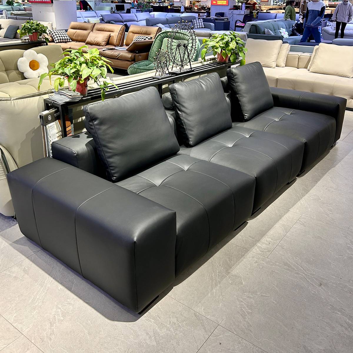 Close-up of the armrest and side profile of the black sofa