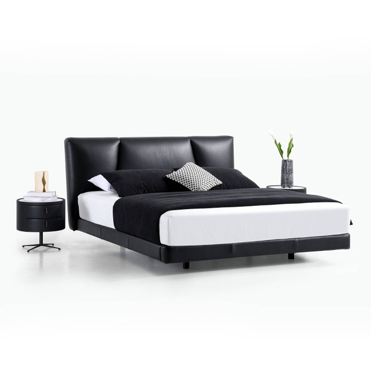 Side angle view of the black leather bed with bedside tables