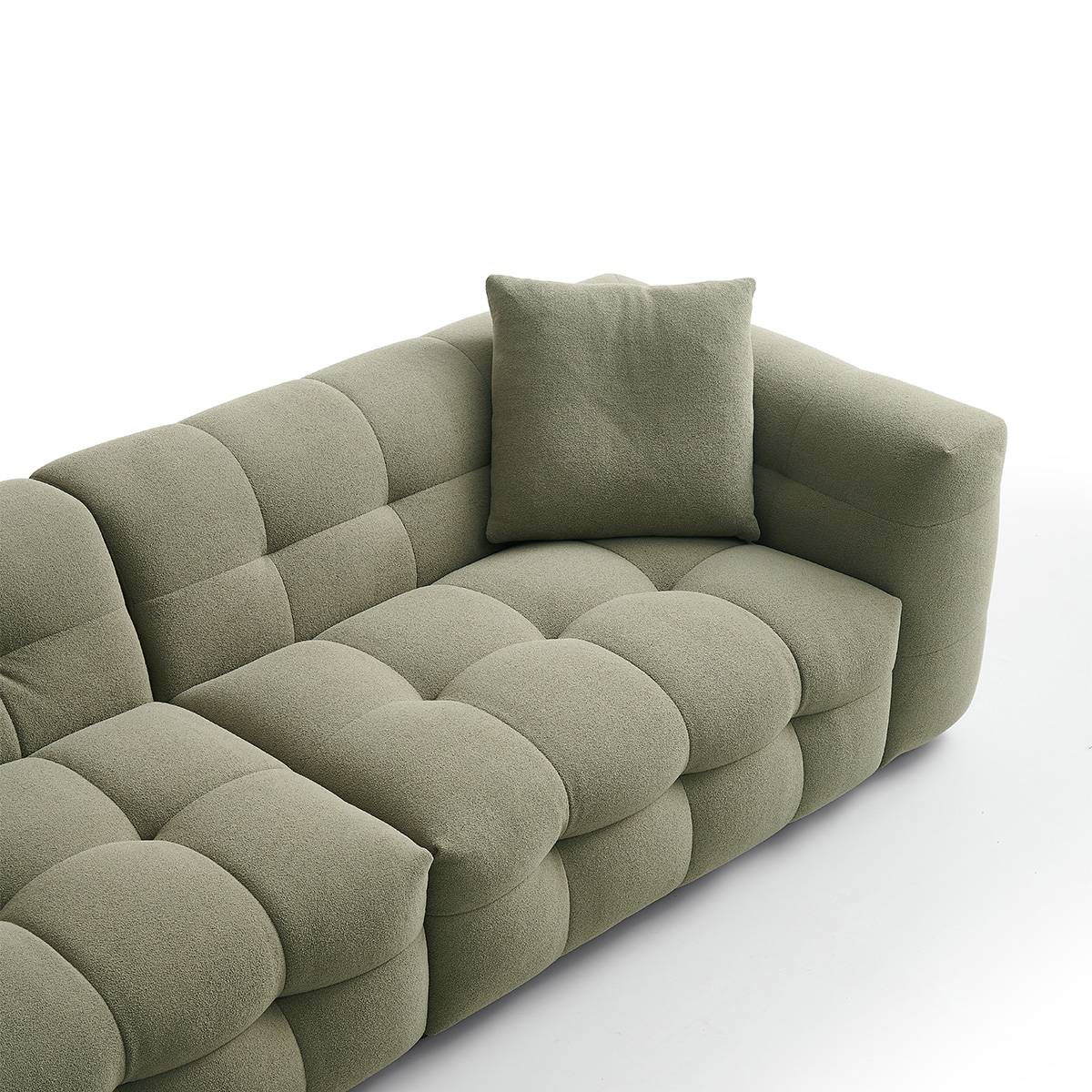 Side profile of the green sofa showing armrest and wooden legs