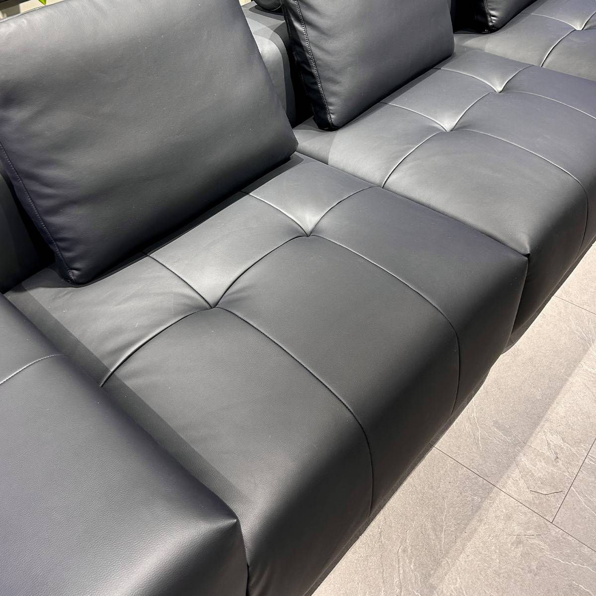 Close-up of the leather texture and stitching on the sofa seat