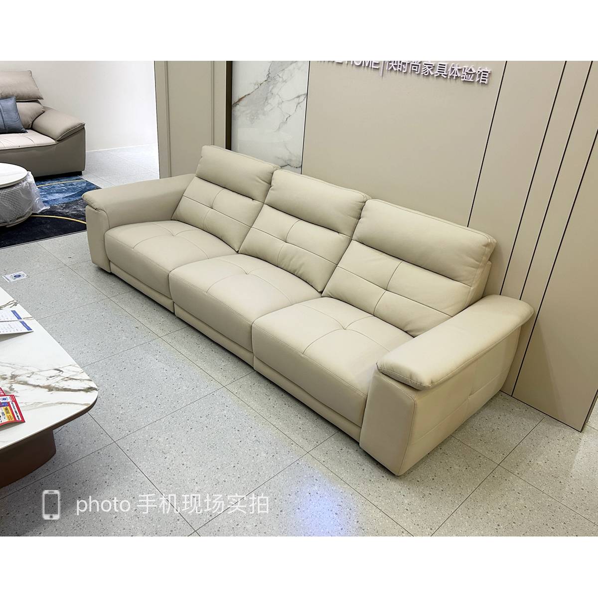 Front view of the beige leather sofa in a showroom
