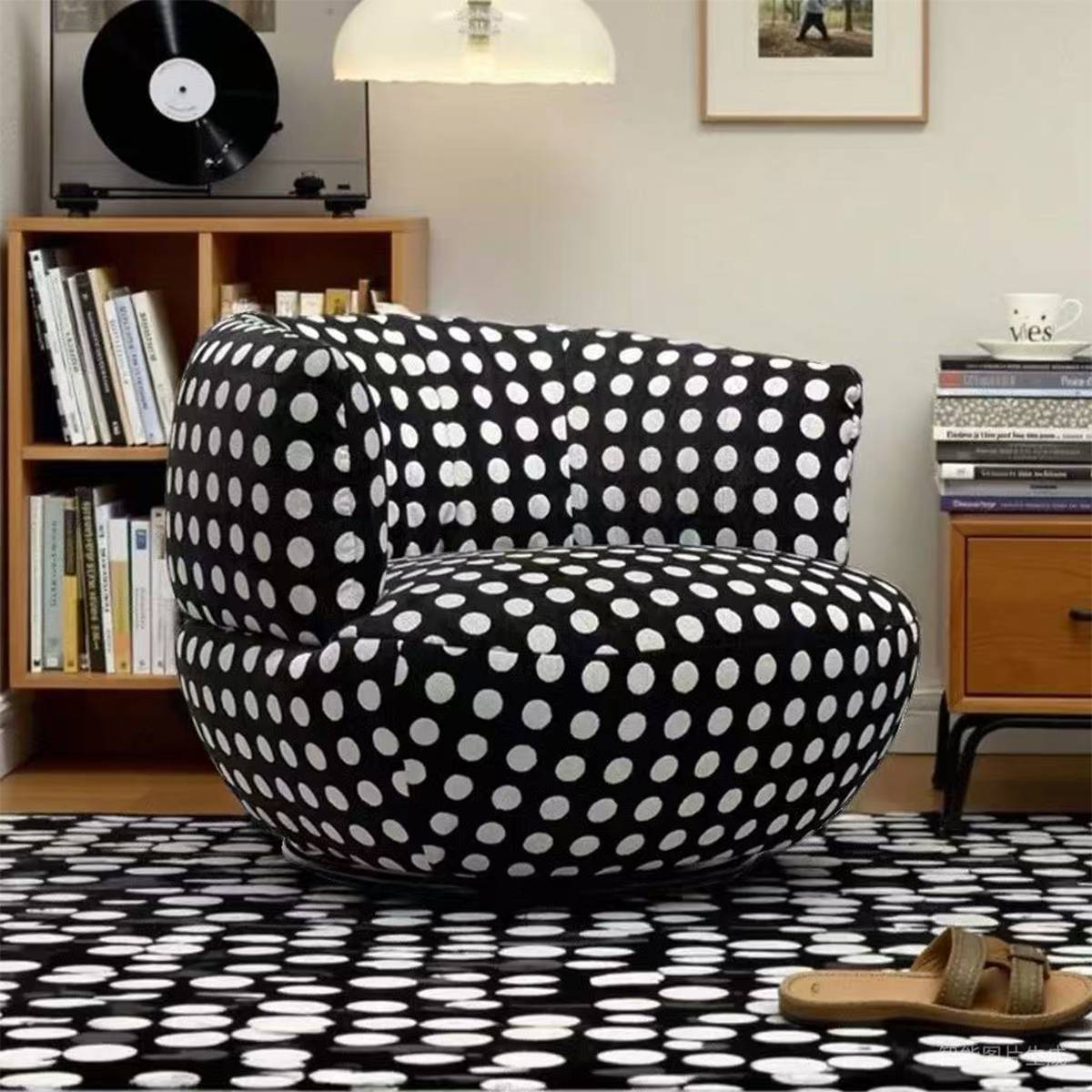 Polka dot lounge chair in a living room setting with a record player