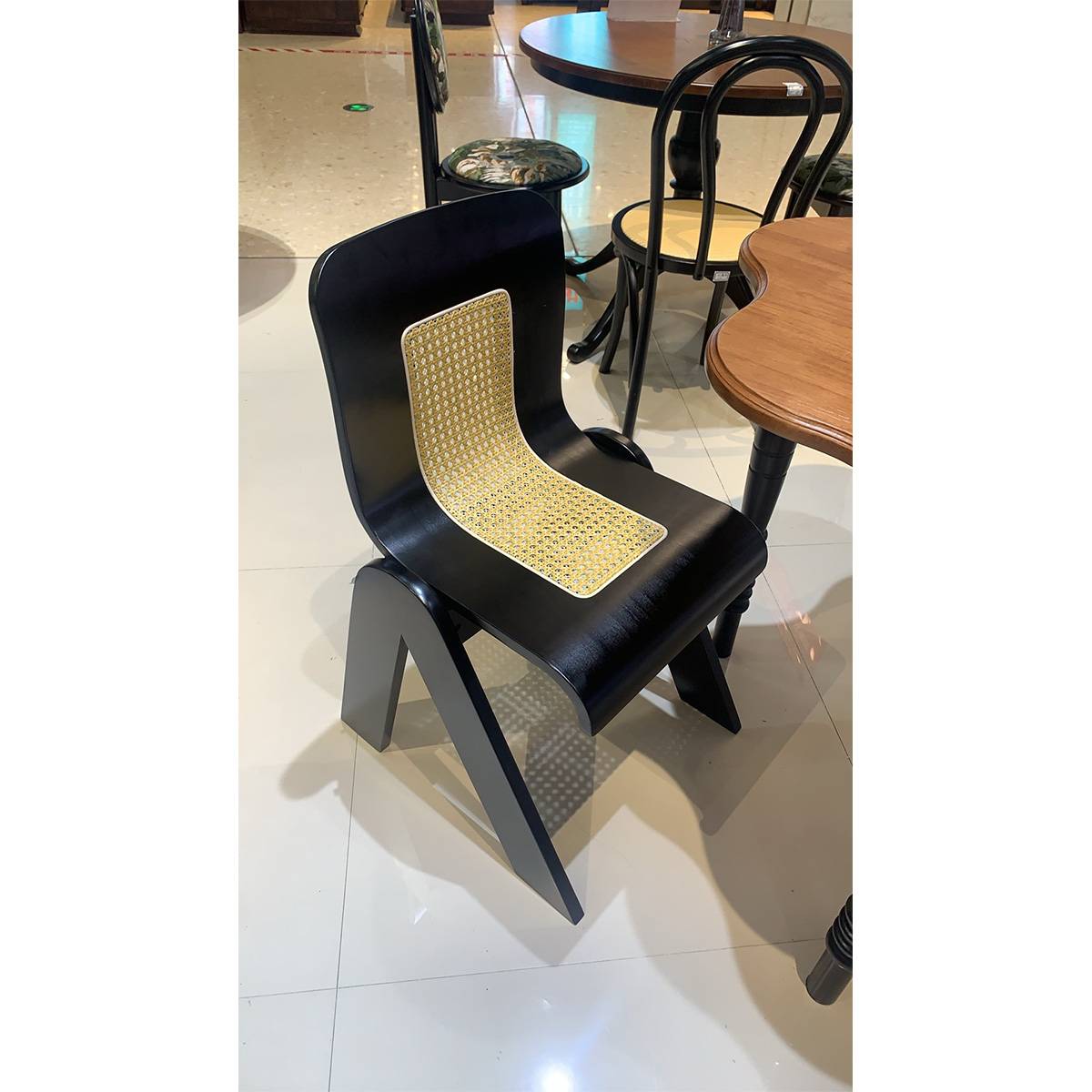 Side view of the black mid-century dining chair with rattan inlay
