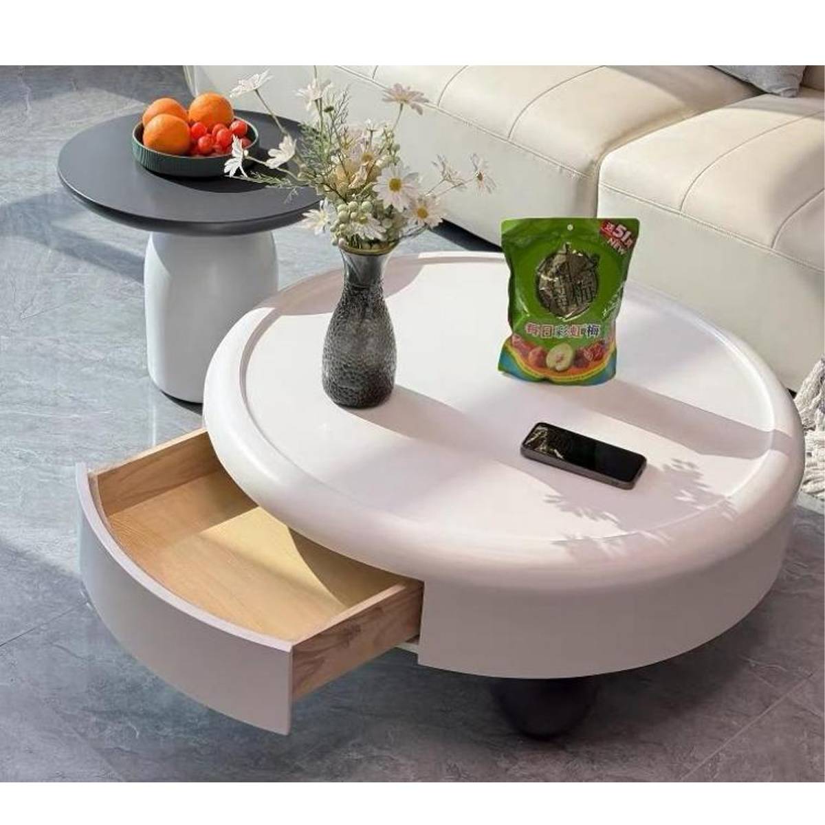 Close-up of the coffee table showing the open wooden drawer and items on the surface