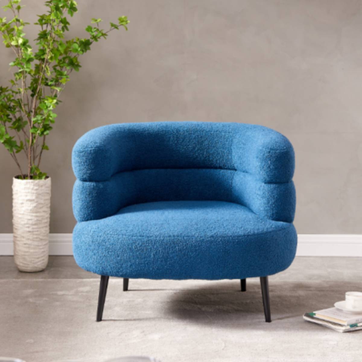 Front view of the blue lounge chair showing the curved backrest and seat