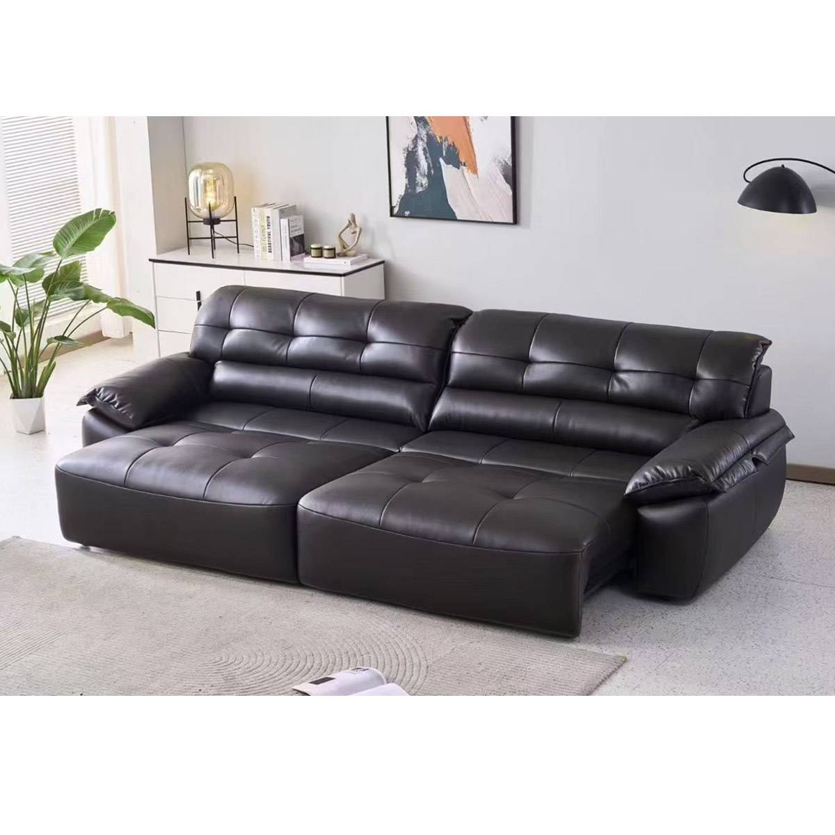 Front view of the black sofa in a showroom setting with a unique oval window in the background