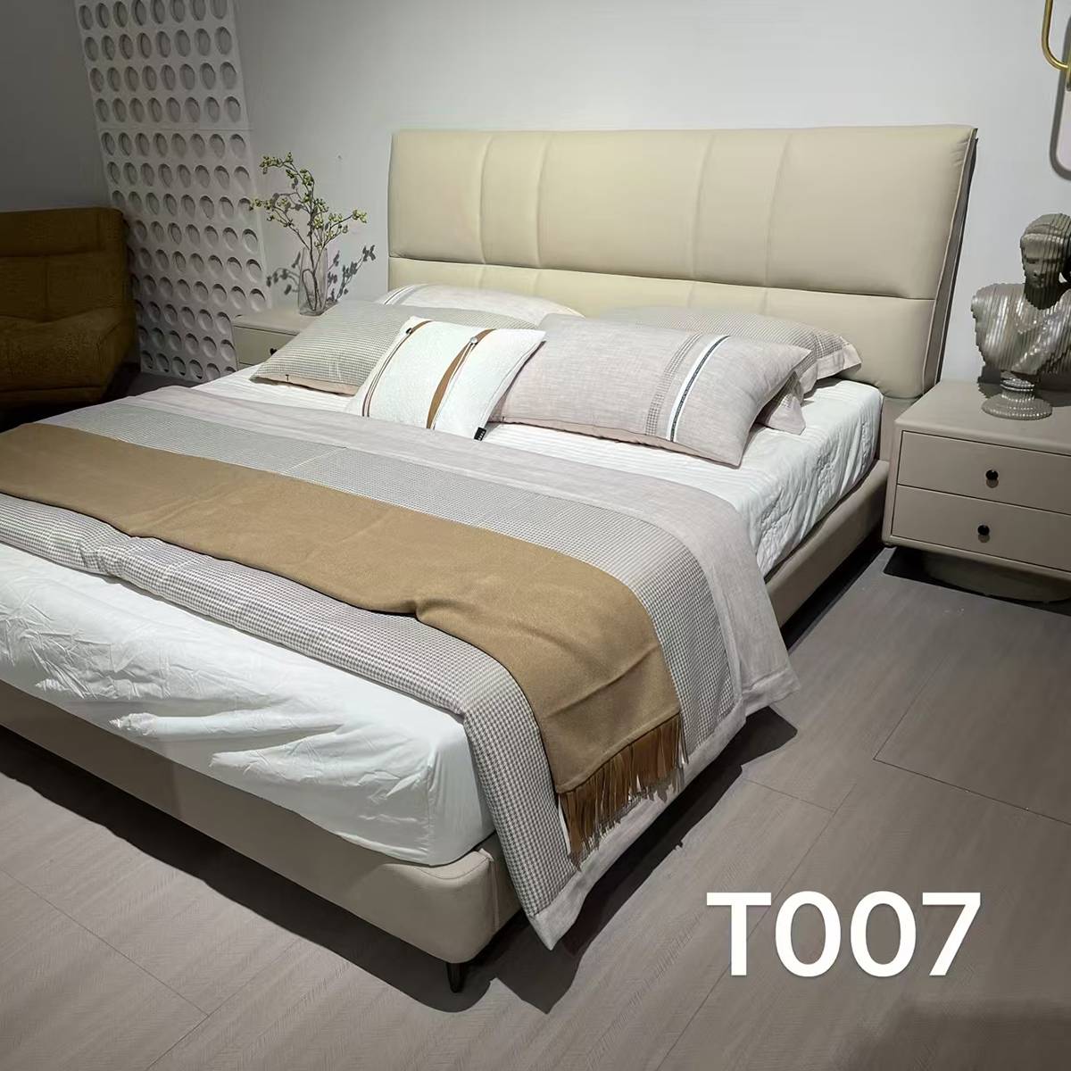 Full view of the bed in a bedroom setting with bedding and bedside tables