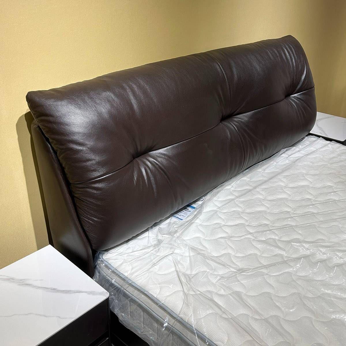 Close-up detail of the tufted leather headboard and mattress