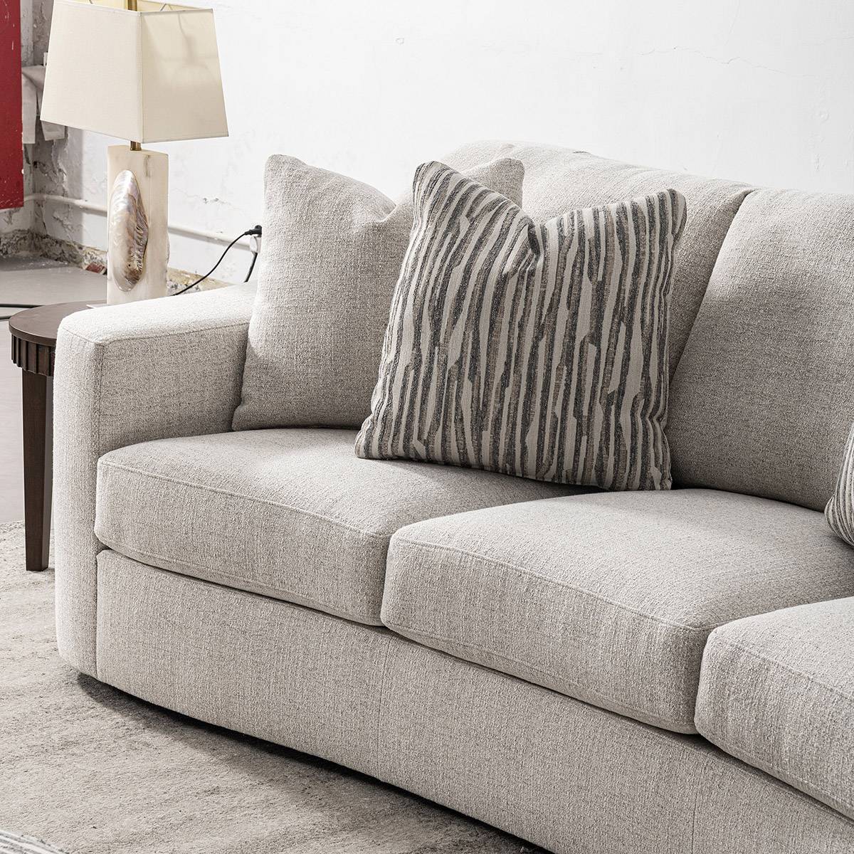 Close-up view of the sofa armrest and striped throw pillow