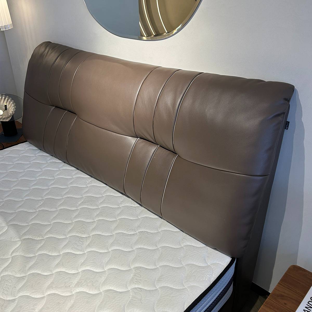 Close-up detail of the top-grain leather headboard showing the stitching and texture.