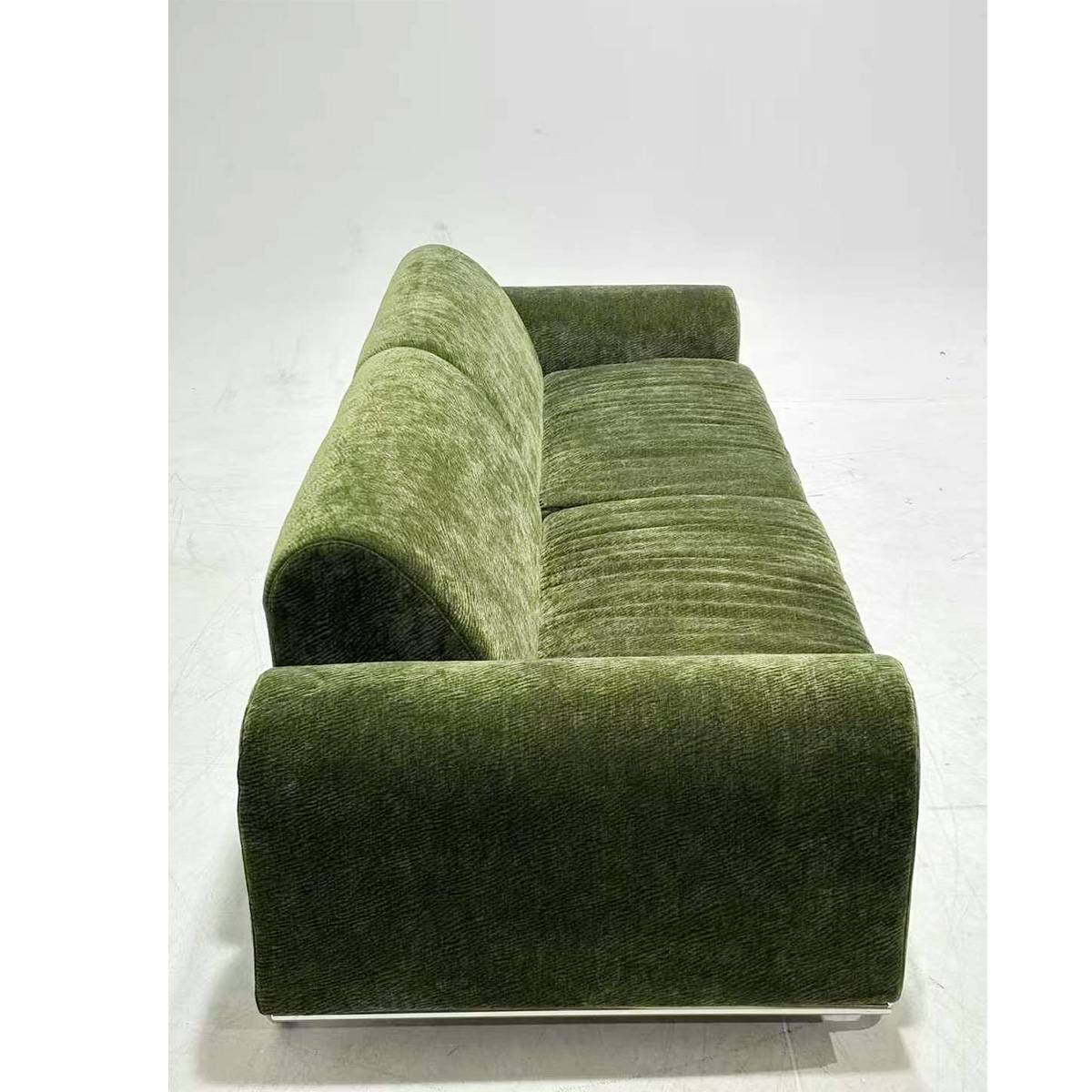 Side view highlighting the rolled armrests and texture of the green fabric