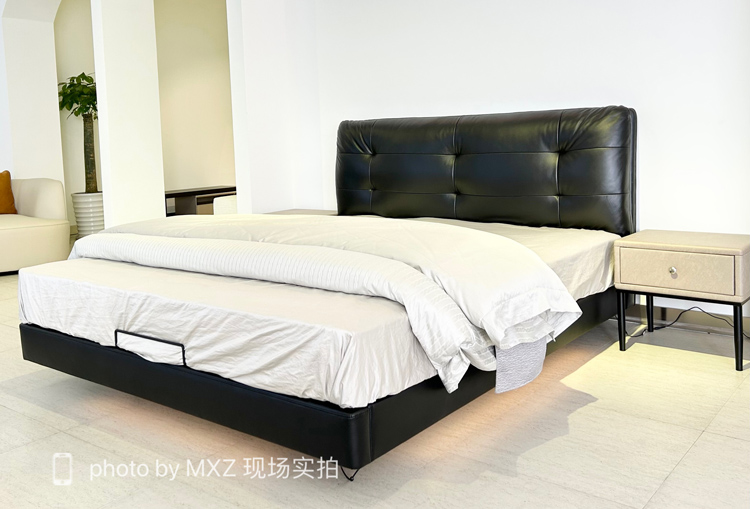 Full view of the black leather floating bed in a bedroom setting with a bedside table