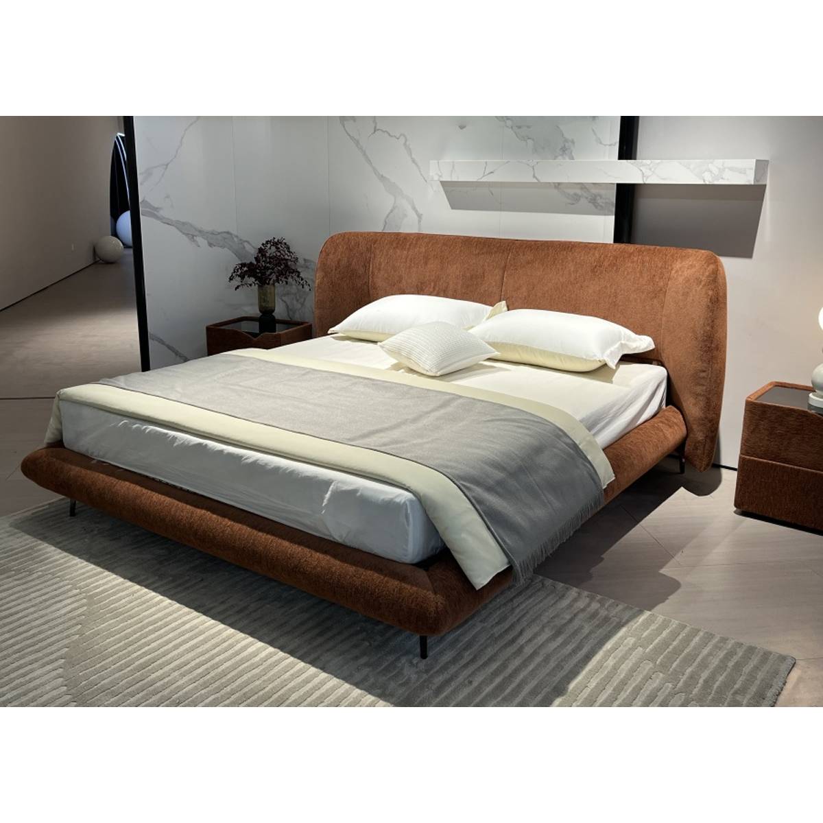 Angled view of the brown upholstered bed showing the headboard and footboard design