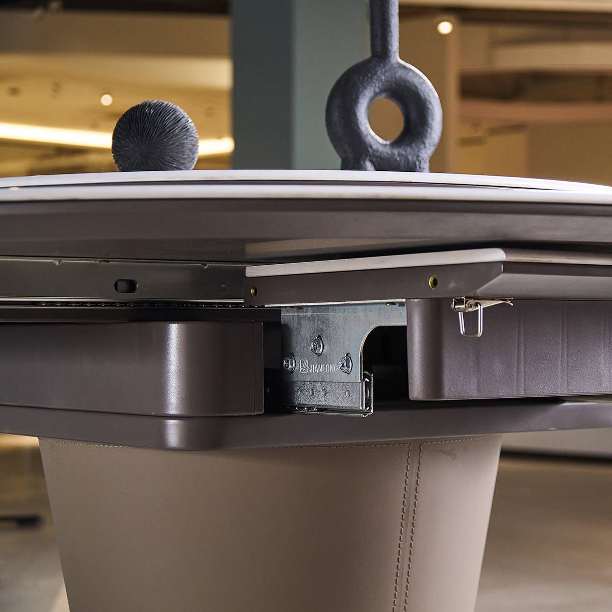 Close-up view of the dining table's extension mechanism and leather base