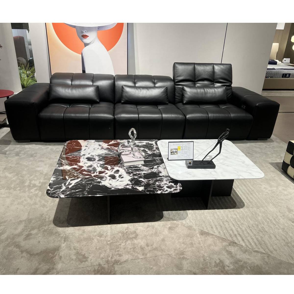 Full view of the coffee table set in a showroom setting with a black leather sofa