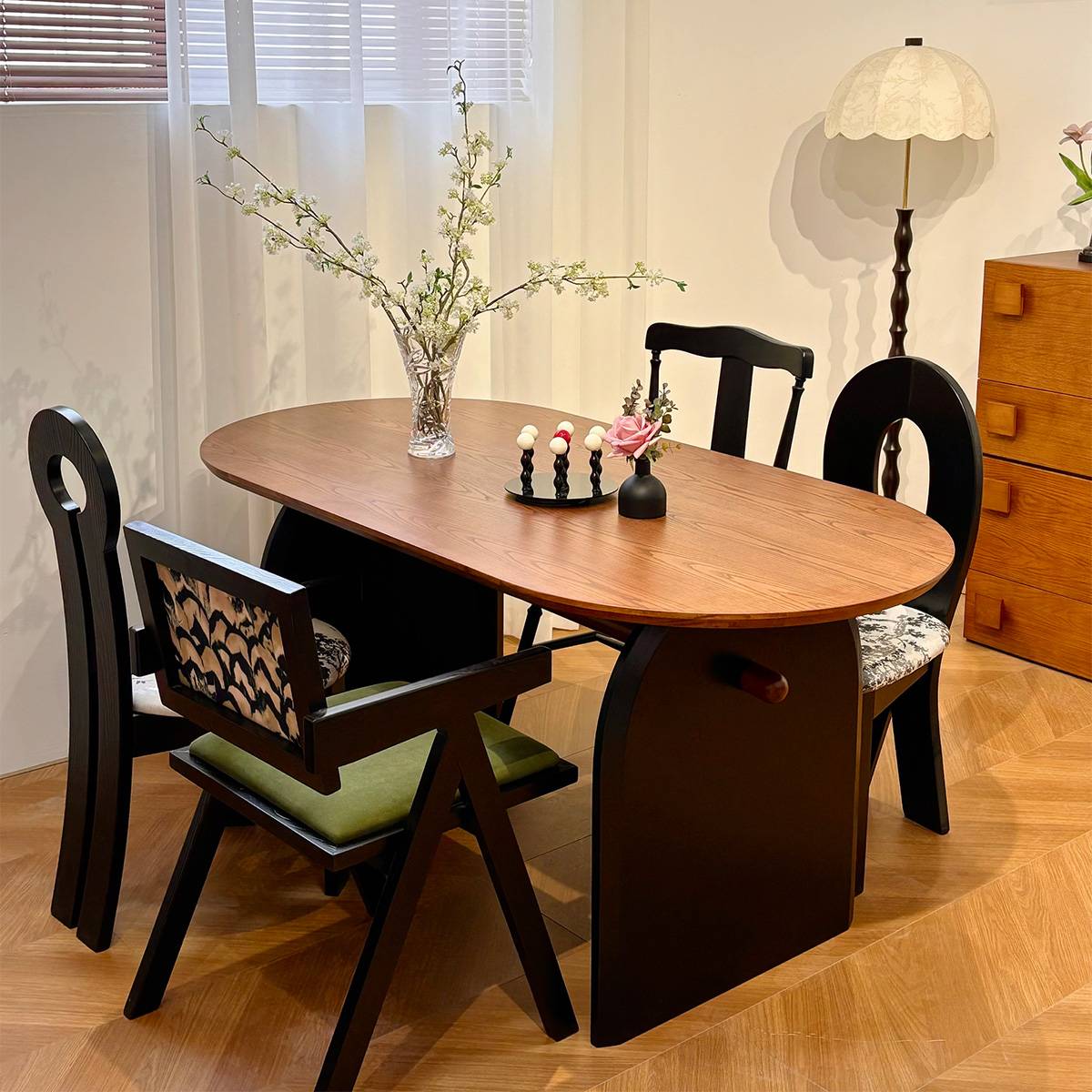 Walnut finish dining table with mixed style chairs and decorative flowers