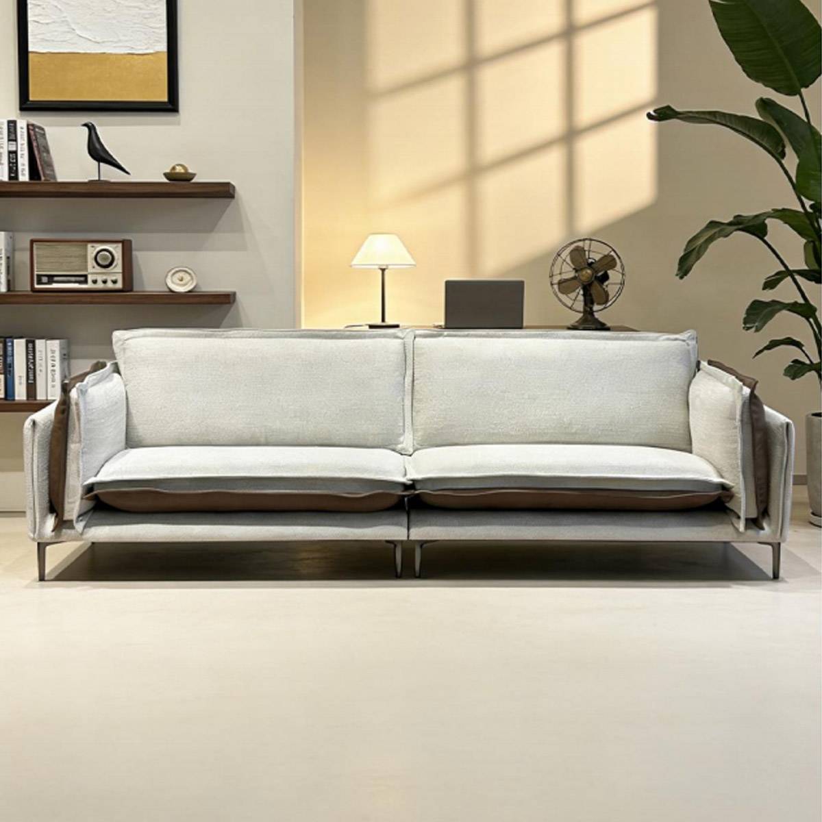 Front view of the sofa in a light grey fabric and brown leather colorway