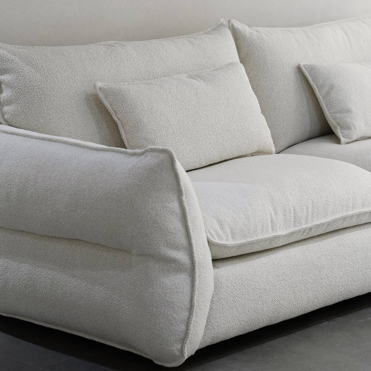 Side angle view of the sofa highlighting the back cushions and seat depth.