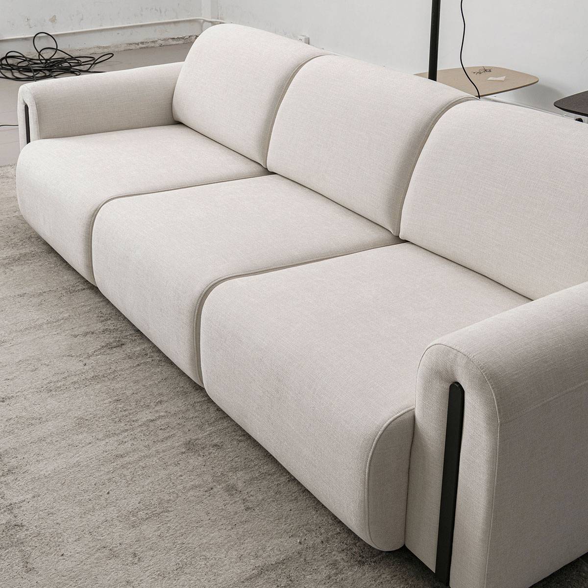 Side angle view of the sofa showing the fabric texture and seat cushions.