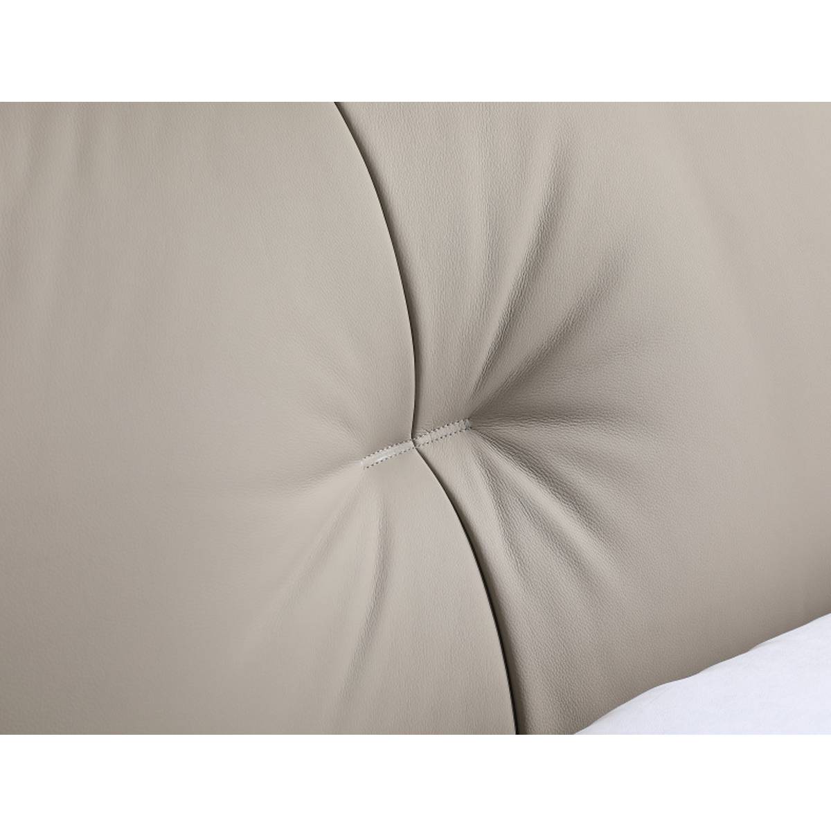 Close-up detail of the beige genuine leather tufted headboard showing stitching and texture