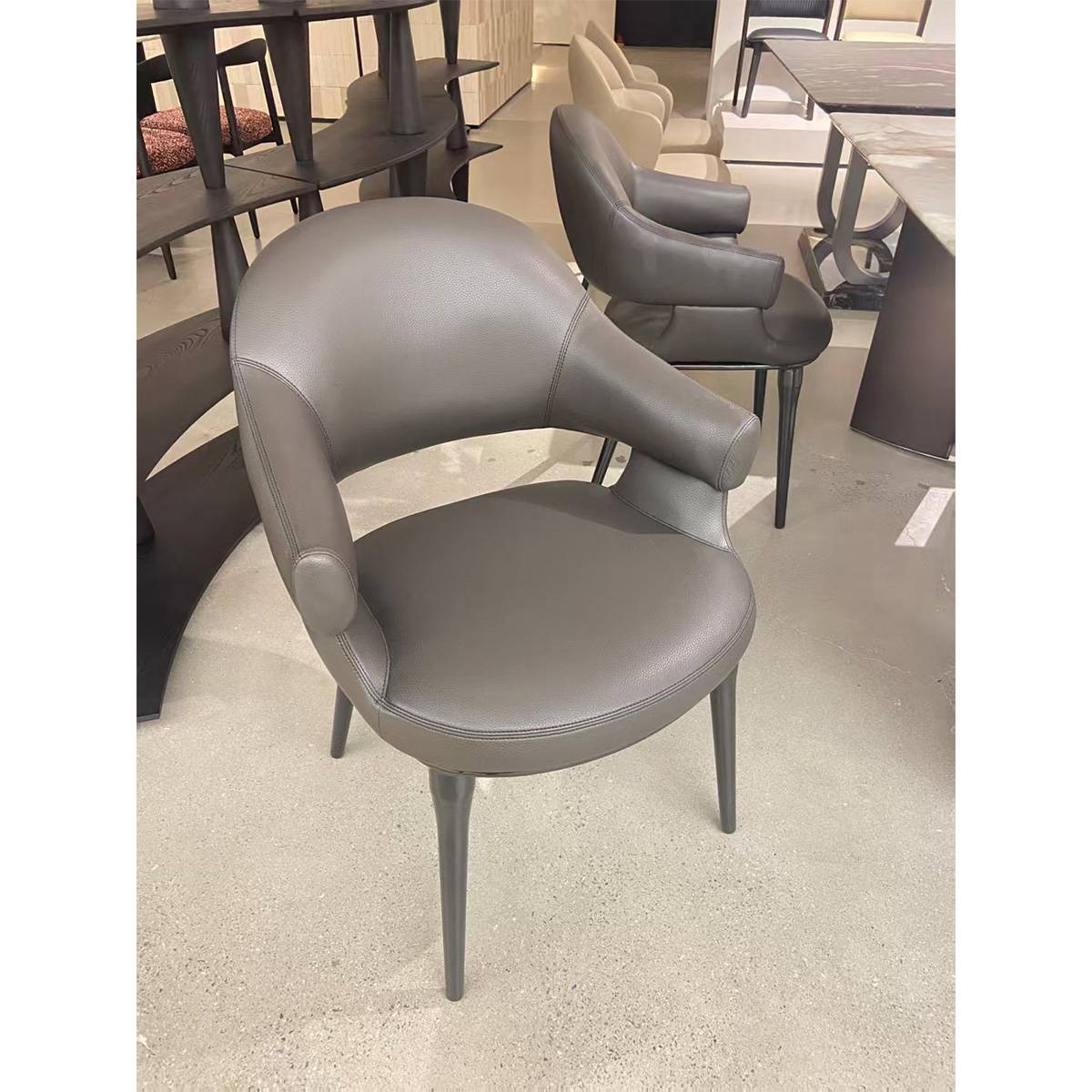 Grey modern dining chair in a showroom setting