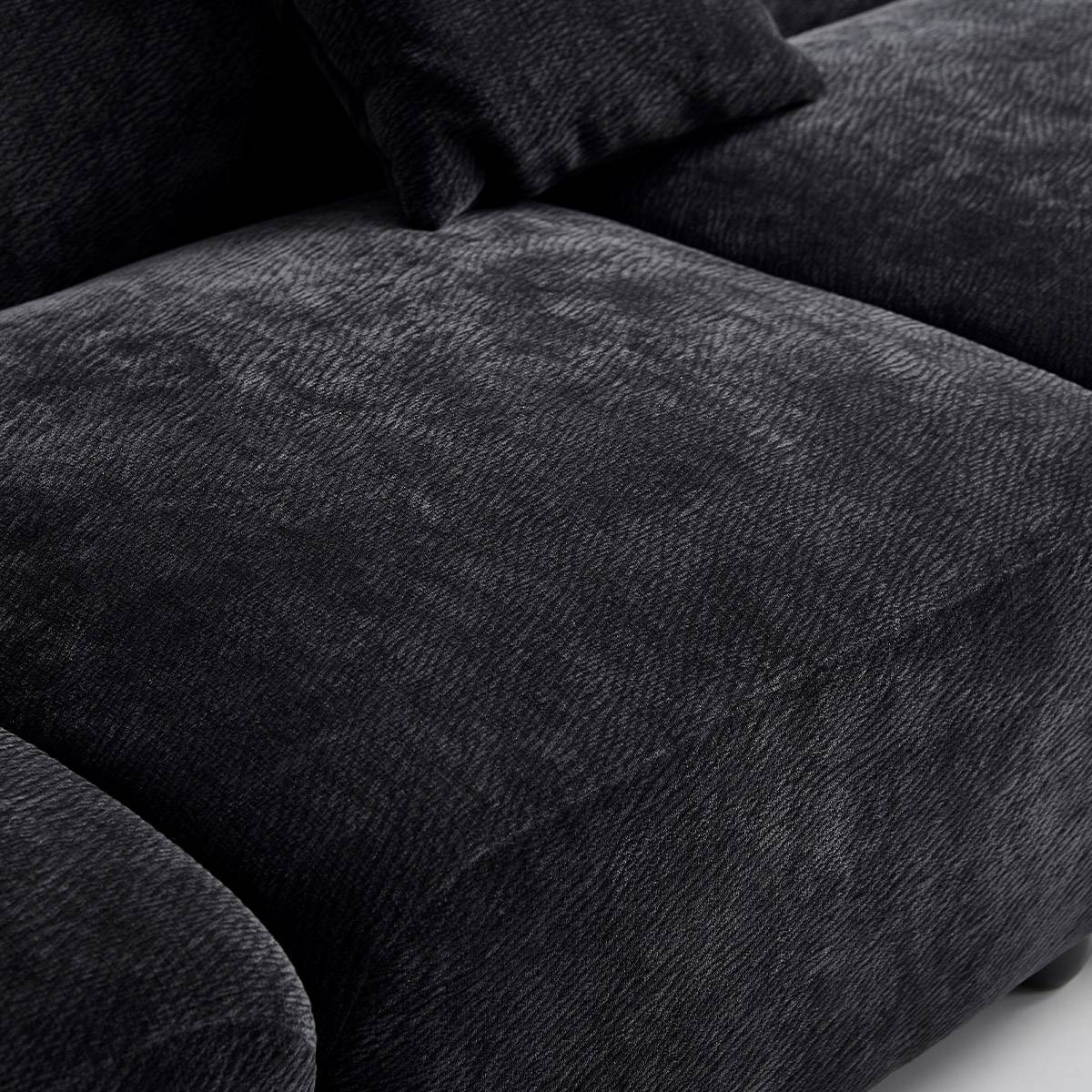 Extreme close-up of the black Sakura velvet fabric texture on the seat cushion.