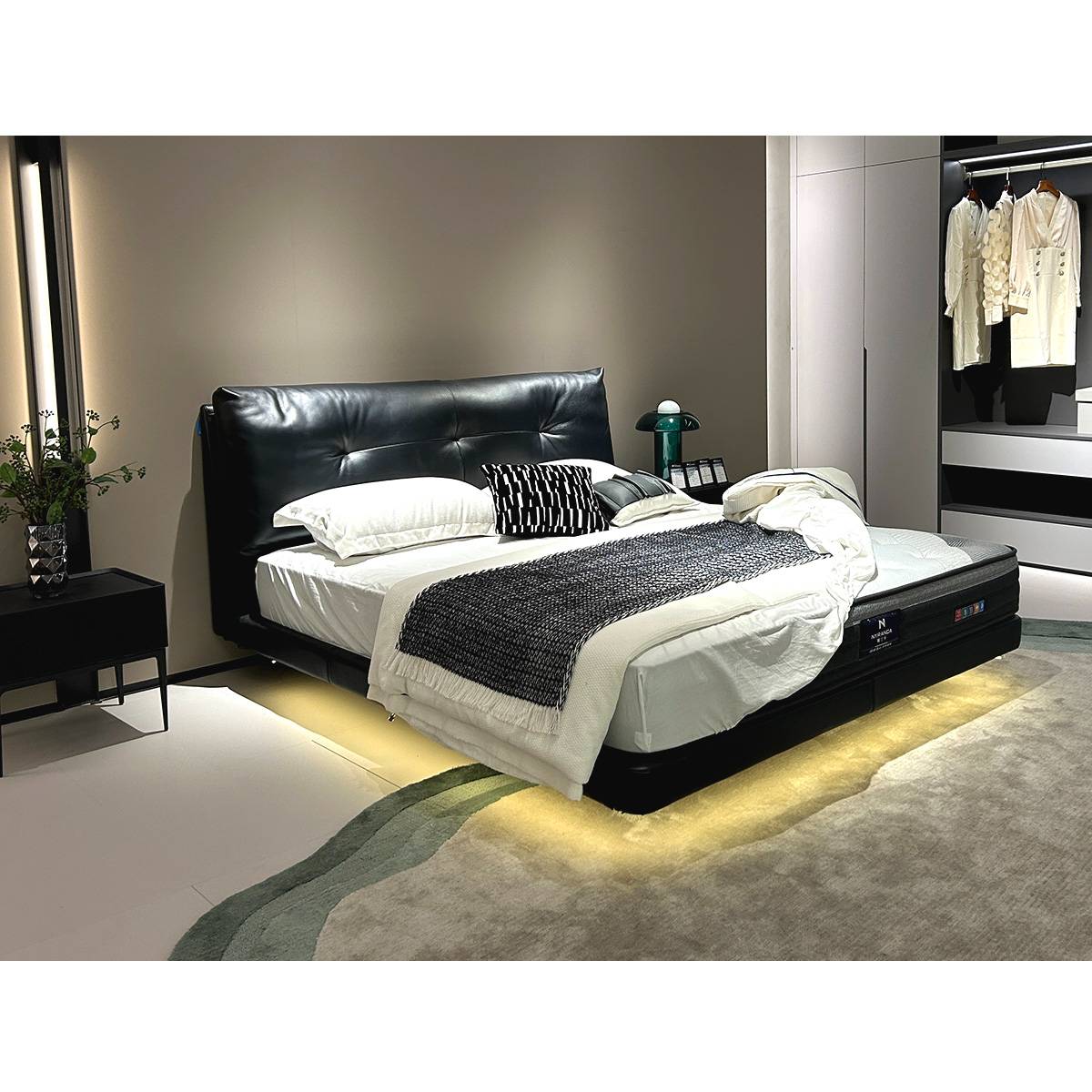Full view of the black floating bed in a modern bedroom setting with LED lighting
