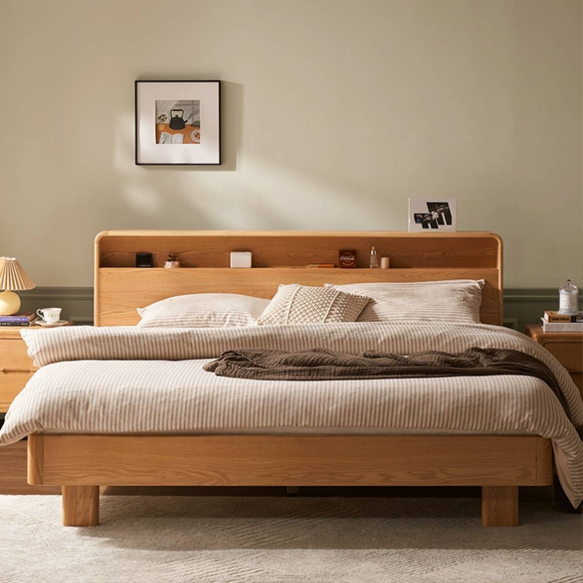 Front view of the bed with striped bedding and a brown throw blanket.