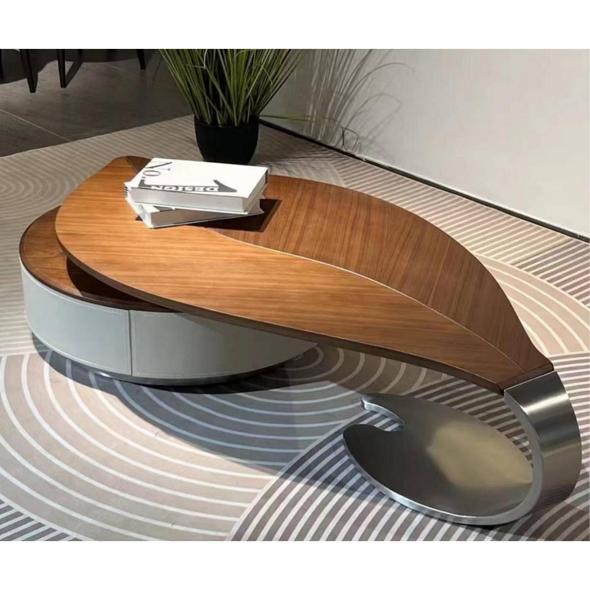 Close-up view of the coffee table showing the wood grain, stainless steel base, and books on top.