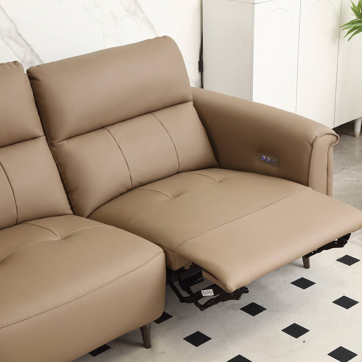 Close-up of hand pressing into the genuine leather backrest to demonstrate material softness and texture.