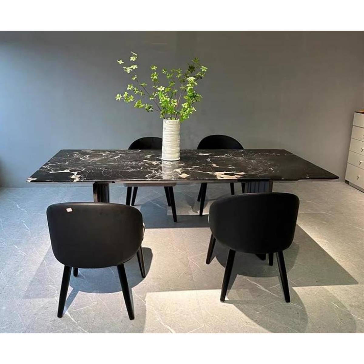 Front view of Black Rose marble dining table with black chairs
