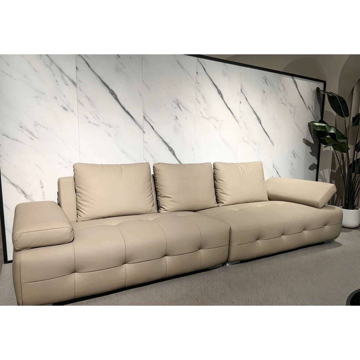 Beige eco-leather straight sofa against a marble wall background.